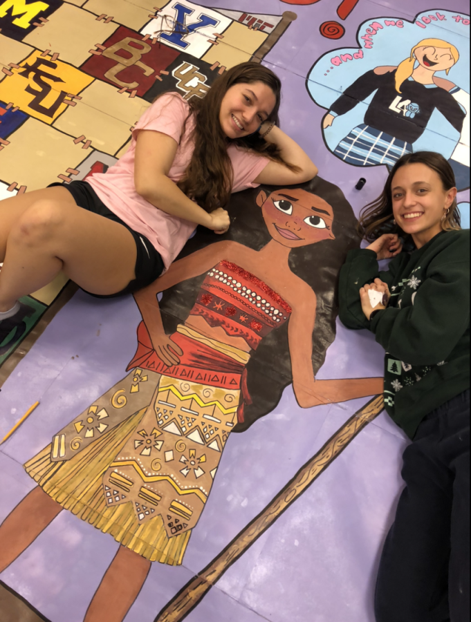 Seniors Jacquelyn Santa Maria and Mica Garcia help out with the senior wall and checking on the details.