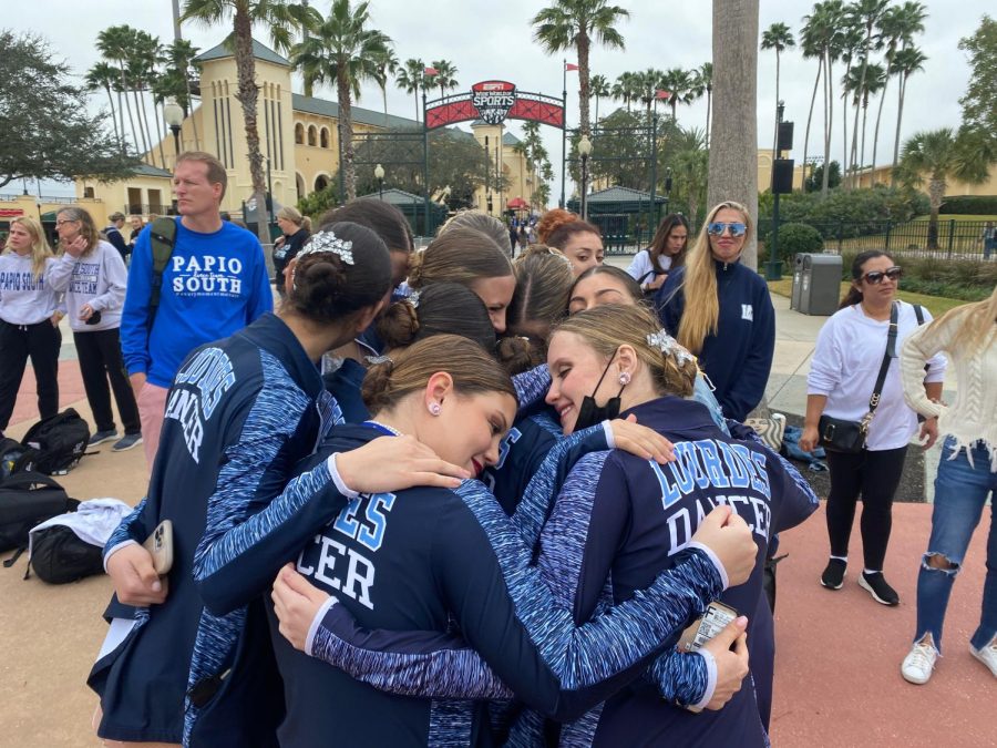 JUST THE BEGINNING: The JV team joins in a group hug with their coach, Melissa Martinez, after placing 5th in the nation for their jazz routine. Martinez was extremely proud of these girls and how far the team has come in just a few short years, and sees this as the beginning of history for the Lourdes Dancers. “I saw so much potential in this team when I first became their coach two years ago, and I’m so emotional about how they’ve been able to make it to UDA and even place,” Martinez said.