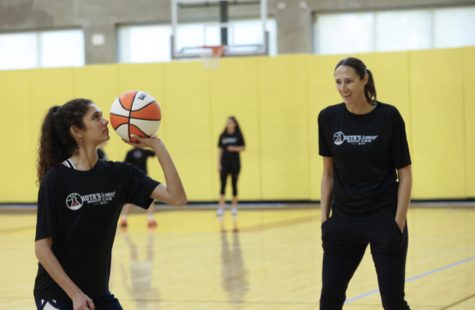 Junior Luciana Picasso practicing shooting a basketball with Ruth Riley.