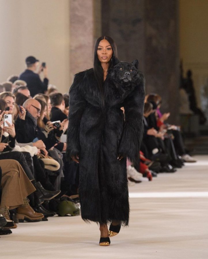 Naomi Campbell walks the Schiaparelli show with a fake wolfs head on her shoulder.
