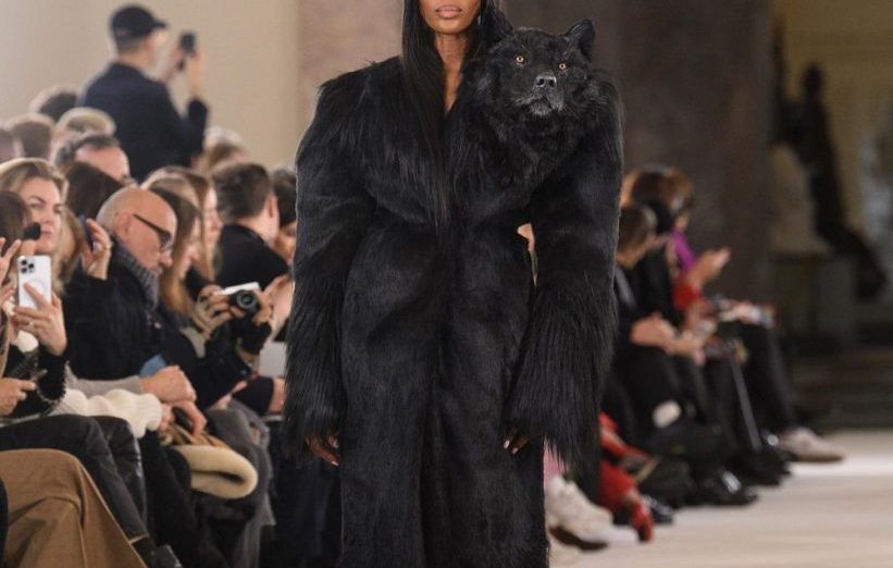 Naomi Campbell walks the Schiaparelli show with a fake wolfs head on her shoulder.