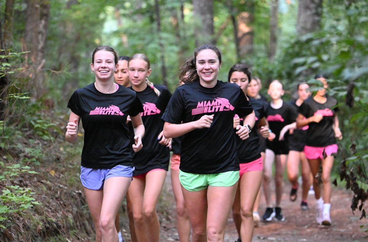 Co-captains Cristina Sanchez and Olivia Rodriguez run through a trail in the woods during training.