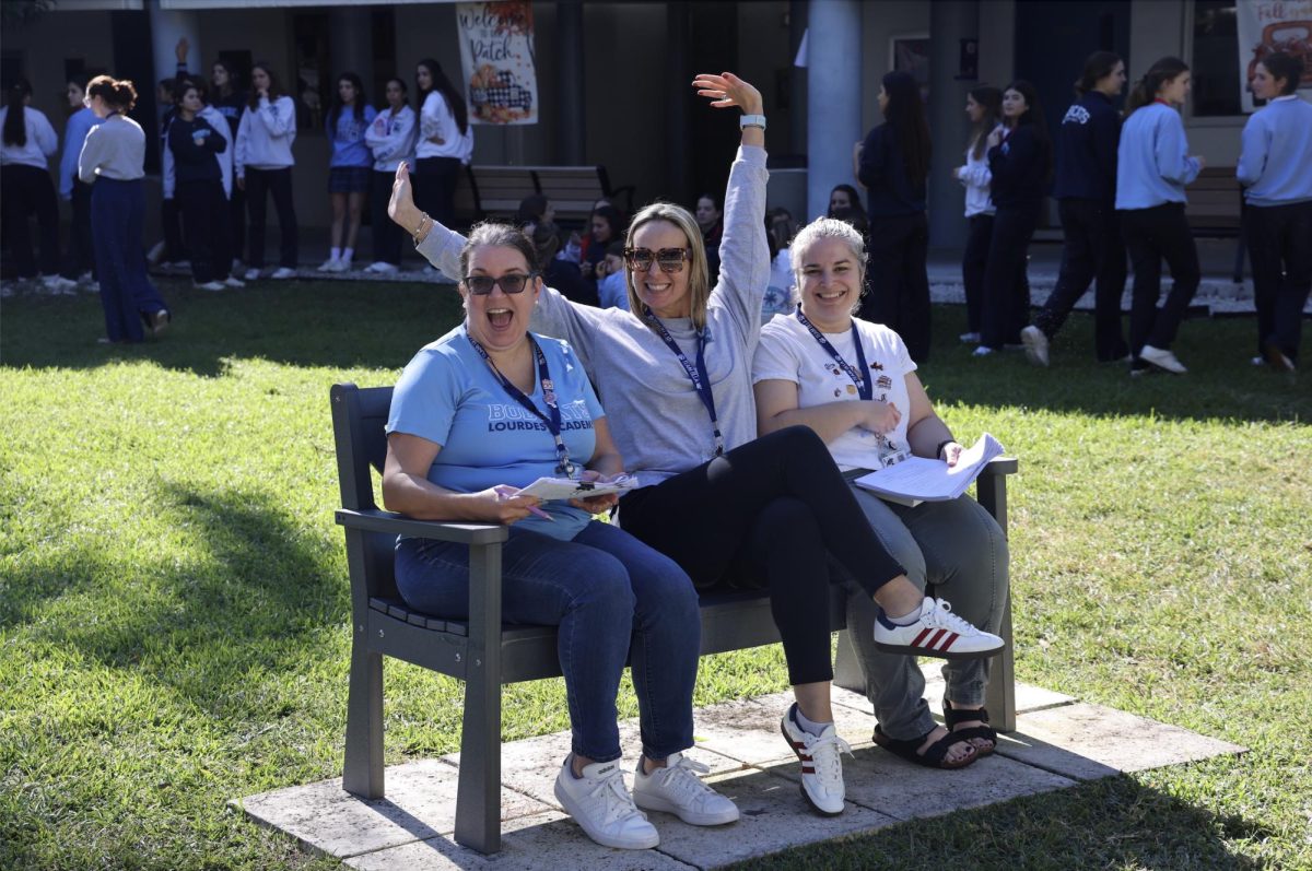 Mrs. Vazquez, Mrs. Franyie and Mrs. Castaneda respectively sitting and cheering on each grade level as they race to the finish line to complete their boxes.